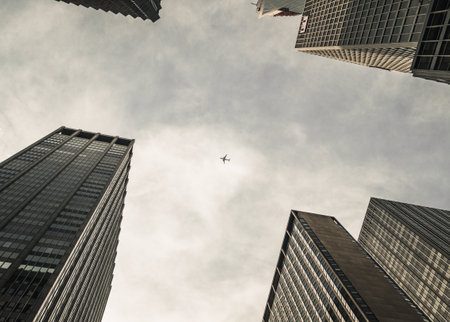 A low angle shot of skyscrapers in NYC under the cloudy skyの写真素材