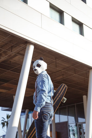 Hipster with panda bear mask and longboardの写真素材