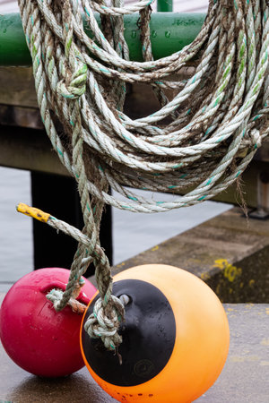 Two round marker buoys in orange and dark red hang on ropes on Heligoland.の写真素材