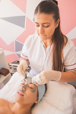 Young Woman Enjoying a Day at the Spa. Performing different treatments for the care of your skin and face.の写真素材