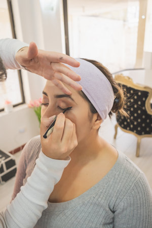 Young woman getting ready to put on makeup for a special event. In a makeup center enjoying this day.の写真素材