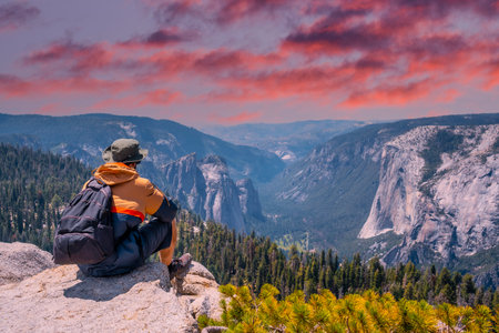 A young winged seated Taft point looking at Yosemite National Park and El Capitan in sunset. United Statesの写真素材
