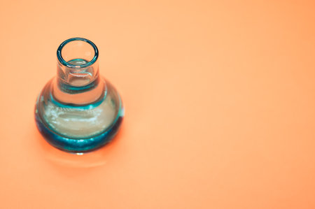 A crystal flower vase isolated on a pastel orange background with free space for textの写真素材