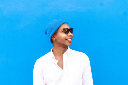 Portrait of a black African American or Hispanic man wearing sunglasses smiling positive sun....