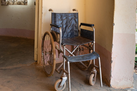 An old, rusty wheelchair is in the hallway of a hospital in Ugandaの写真素材