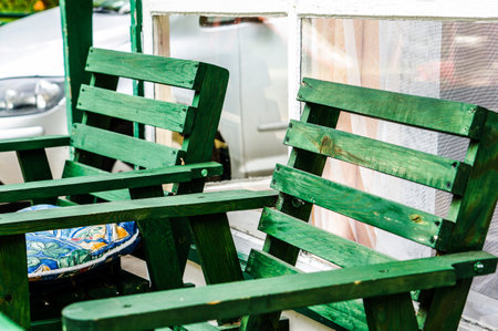 A closeup shot of two wooden garden chairs painted in greenの写真素材