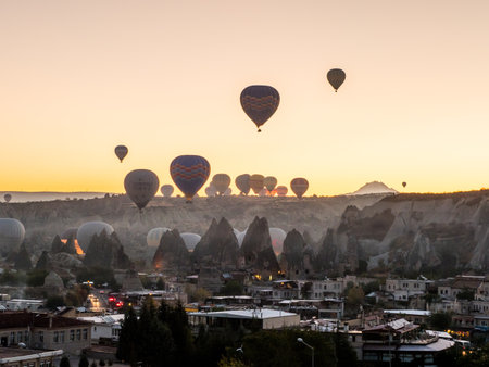 The hot air balloons flying over rocky mountains at scenic sunrise in Cappadocia, Turkeyの写真素材