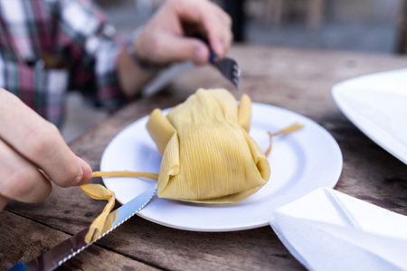 A closeup of a man eating the delicious tamalesの写真素材