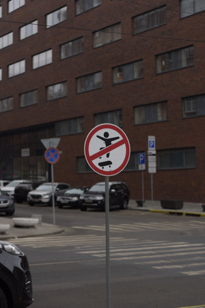 A vertical shot of a NO SKATBORDING SIGN beside a pedestrian crossing in a cityの写真素材