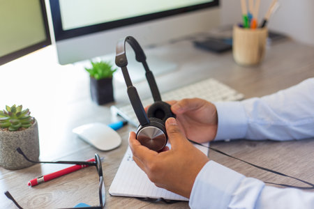 A closeup shot of a businessman holding his earphones at workの写真素材