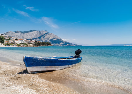 Beautiful summer background with old boat on empty sandy beach near Omis in Croatia.の写真素材