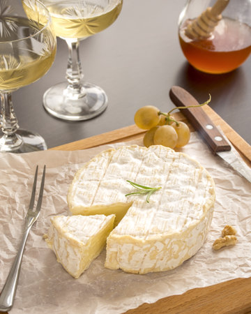 In the photo, we see white wine served with camembert cheese.