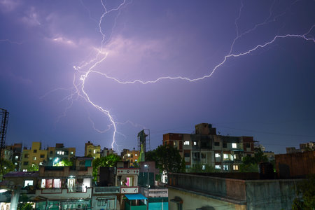 The moment of a massive lightning strike on the purple sky at night over the city