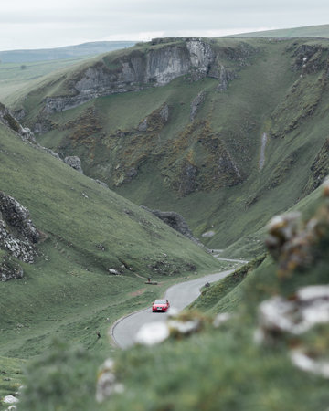 A vertical shot of a road through green mountains