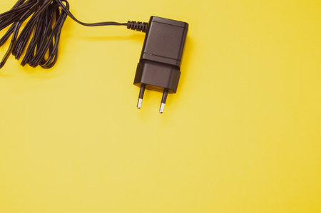 A top view of wired charger adapter isolated on yellow background