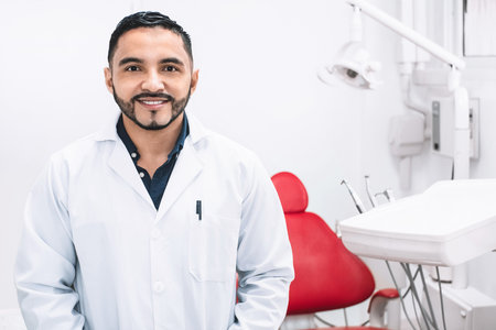 A smiling Latin American dentist in a clinicの写真素材