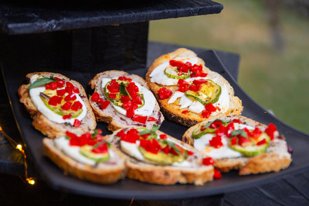 Tasty roasted vegetable bruschetta served on a black plate