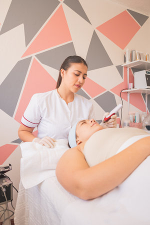 Young Woman Enjoying a Day at the Spa. Performing different treatments for the care of your skin and face.の写真素材