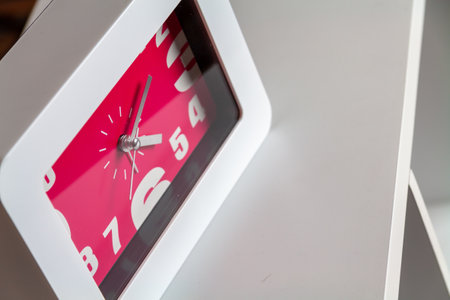 A closeup shot of a white and pink clock