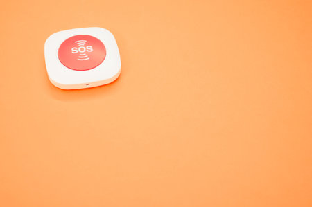 A high angle shot of an SOS button on an orange surfaceの写真素材