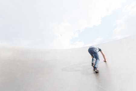 A person climbing a white building under a cloudy skyの写真素材