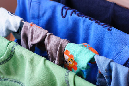 A variation of small children clothes hanging on a drying rackの写真素材