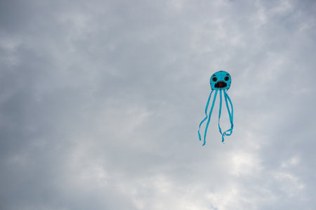 A closeup shot of a kite with a face in a cloudy skyの写真素材