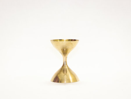A closeup of an antique gold candleholder isolated on a  white background