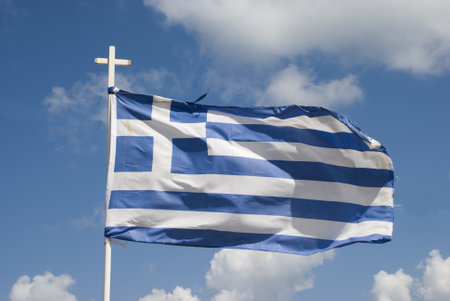 Greek flag on a pole waving in the windの写真素材