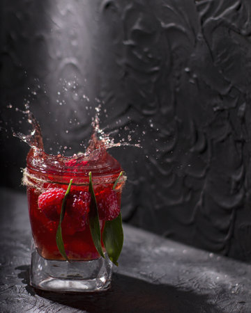 A vertical shot of a red cocktail drink with fresh berries against a gray backgroundの写真素材