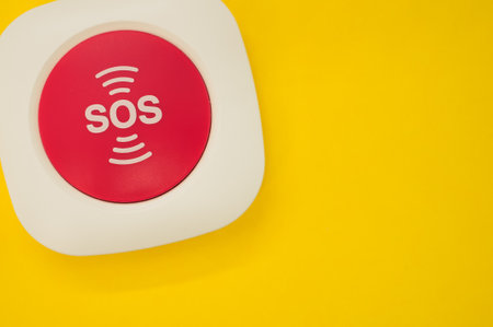 A top view of an SOS button on a yellow surfaceの写真素材