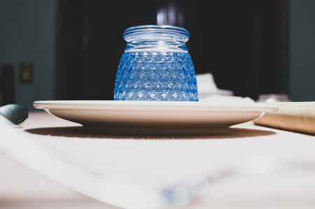 A closeup of patterned glass in a white plate, on a table indoorsの写真素材