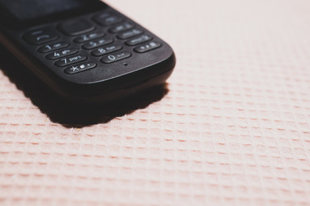 A closeup of an old school button mobile on a patterned surfaceの写真素材