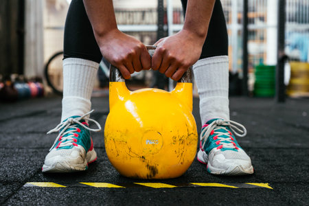 Closeup Up Of Strong Woman Using Kettlebell In Gymの写真素材