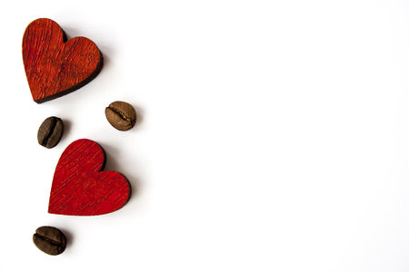 A top view shot of wooden red hearts and coffee beans isolated on a white backgroundの写真素材