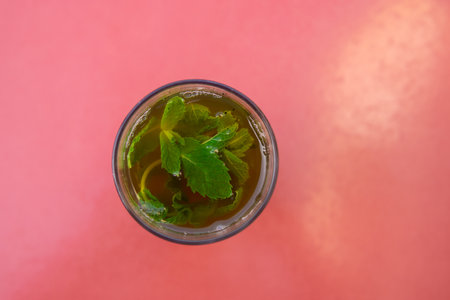 Top view of a Glass of moroccan tea with mint plant with copy space in red backgroundの写真素材
