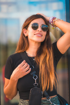 Beautiful young brunette caucasian businesswoman outside the office building walking. With green...