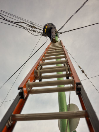 telecommunication technician climbing a ladder working on network maintenance in Buenos Aires city, Argentinaの写真素材