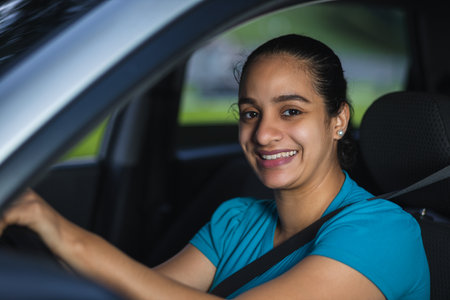 cheerful latin woman while driving her car