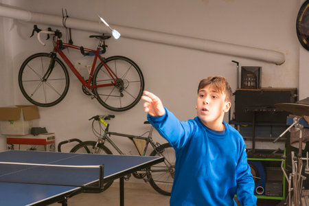 Concentrated caucasian teenager, playing darts in recreation room. Concept of entertainment.の写真素材