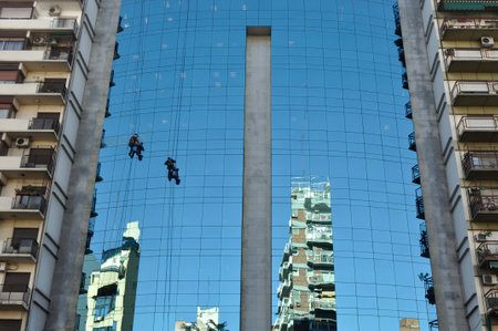 two men cleaning windows on the glass front of a building in Buenos Airesの写真素材