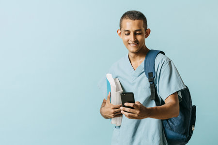 Latin american man health or medical student smiles and holds up a smart phone. concept online...