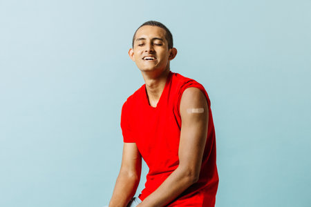 portrait of hispanic man with bandage on his arm. concept vaccination against virus. vaccinated latin americanの写真素材
