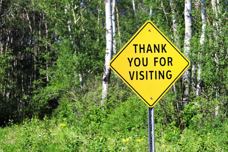 A thank you for visiting sign against a forest background.の写真素材