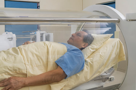 Man lying relaxed inside a cylindrical machine for hyperbaric treatment in a clinic