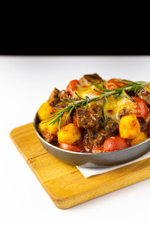 Stew with vegetables in a pan on a cutting board, white backgroundの写真素材