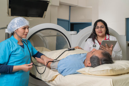 Doctors taking a patient's blood pressure in front of a hyperbaric treatment machine.の写真素材