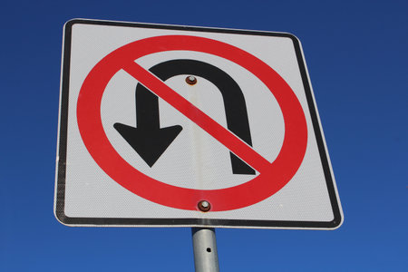 No U-Turn Sign Against Blue Sky.の写真素材