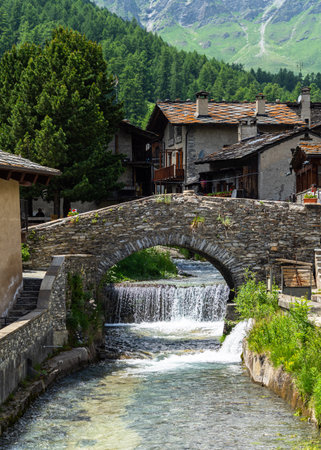 The Varaita river passing under old stone bridge in the village of Chianale, Varaita Valley, Piedmont, Italyの写真素材