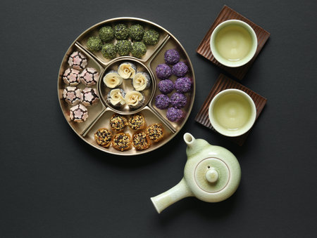 Colorful rice cakes and green tea on black backgroundの写真素材